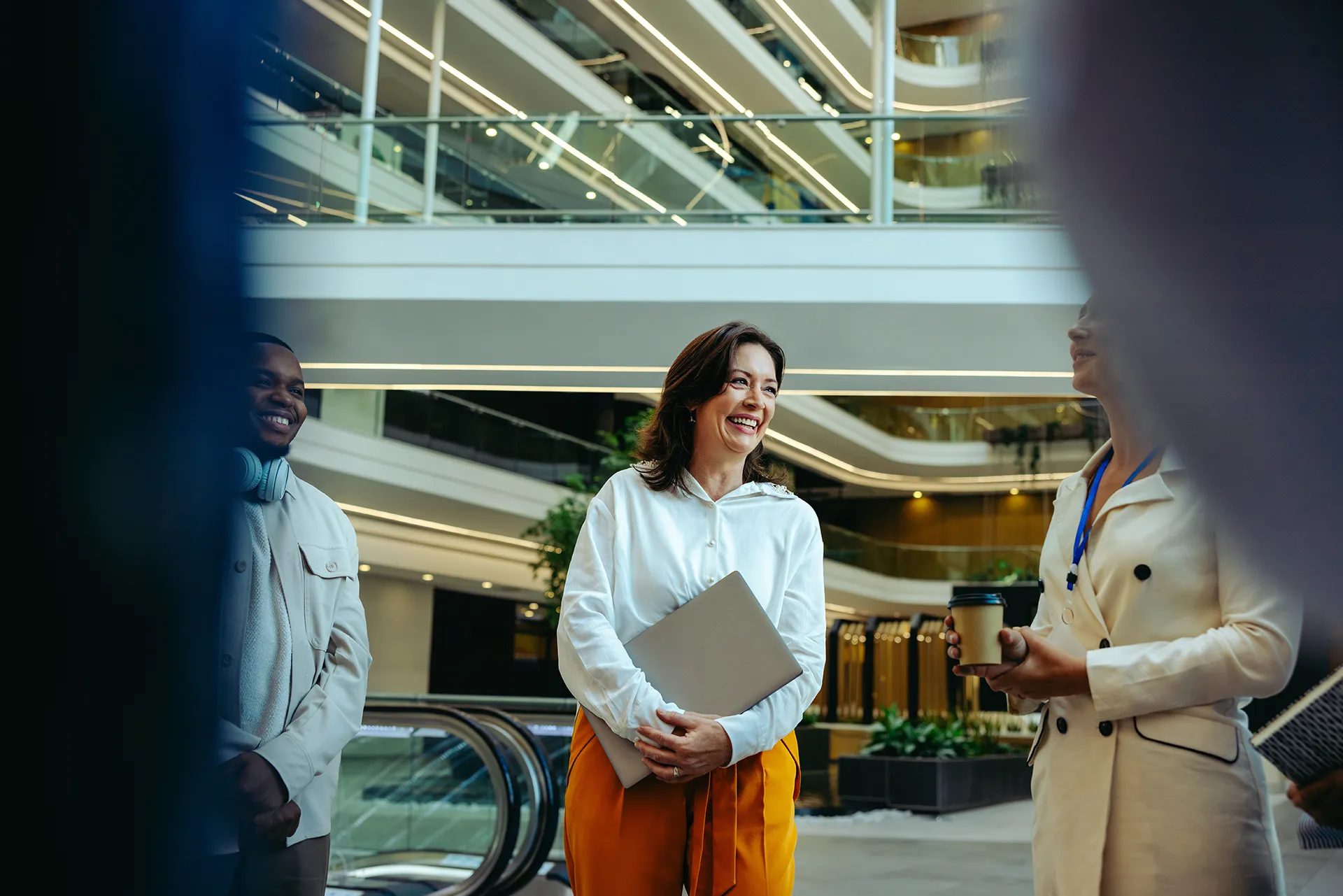 Ein freundliches Team trifft sich in einer modernen Büro-Architektur. Ideal für Themen wie Unternehmenskultur, Zusammenarbeit oder Business Consulting.